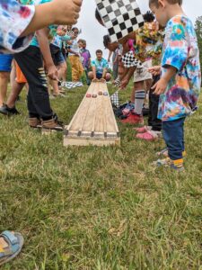 Kids racing toy cars at camp